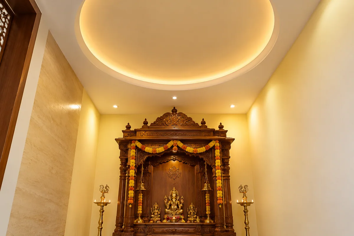 shallow dome false ceiling with cove lighting above a carved wooden mandir